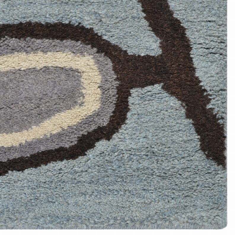 Hand-tufted wool area rug close-up, blue-gray pile with beige rings and dark brown