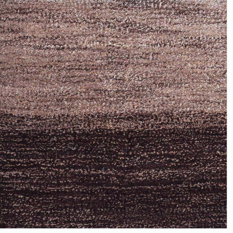 Textured close-up of a multicolor striped area rug in brown, maroon, and blue tones
