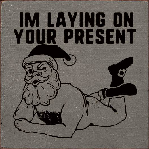 Gray fabric graphic featuring cartoon Santa and text 'I'm laying on your present'