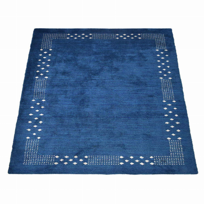 Blue area rug square with white corner lattice border and open center.