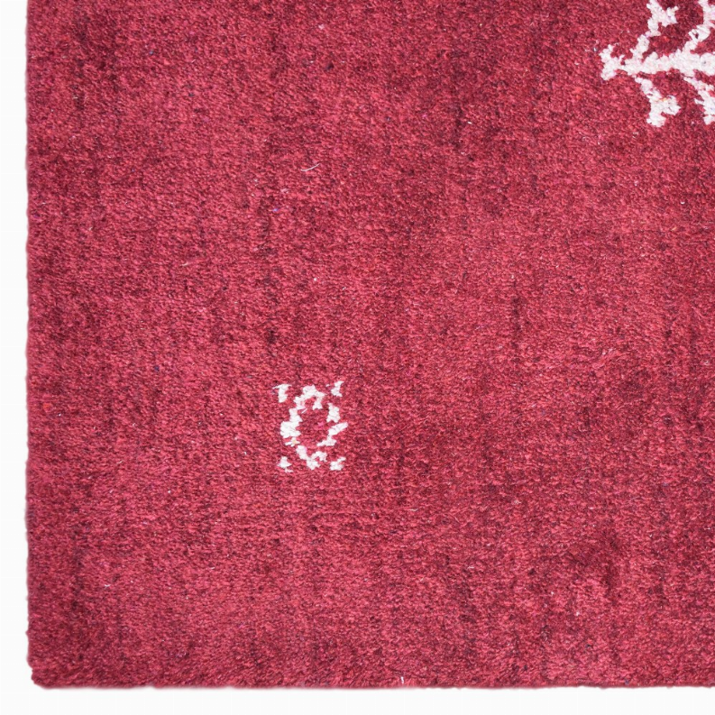 Maroon area rug surface with white small motifs and high-pile loop texture close-up