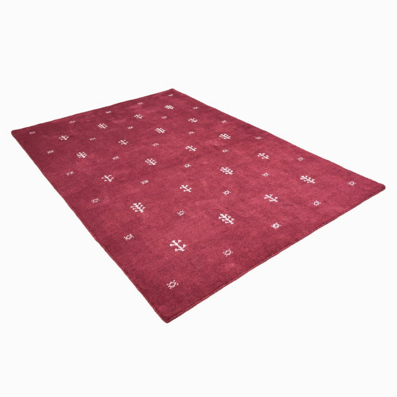 Red rectangular area rug with repeating white geometric motifs and short dense pile