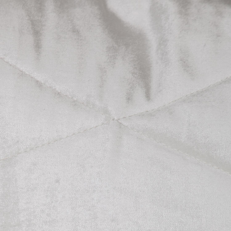 Close-up of light gray quilted pillow with cross-stitched channel seams