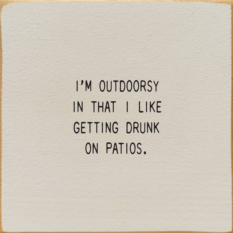 Outdoor patio quote wall art with black text on a white square