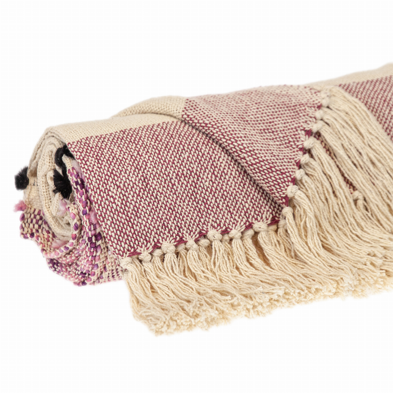 Folded beige and mauve throw blanket with textured weave and long cream fringe along edge