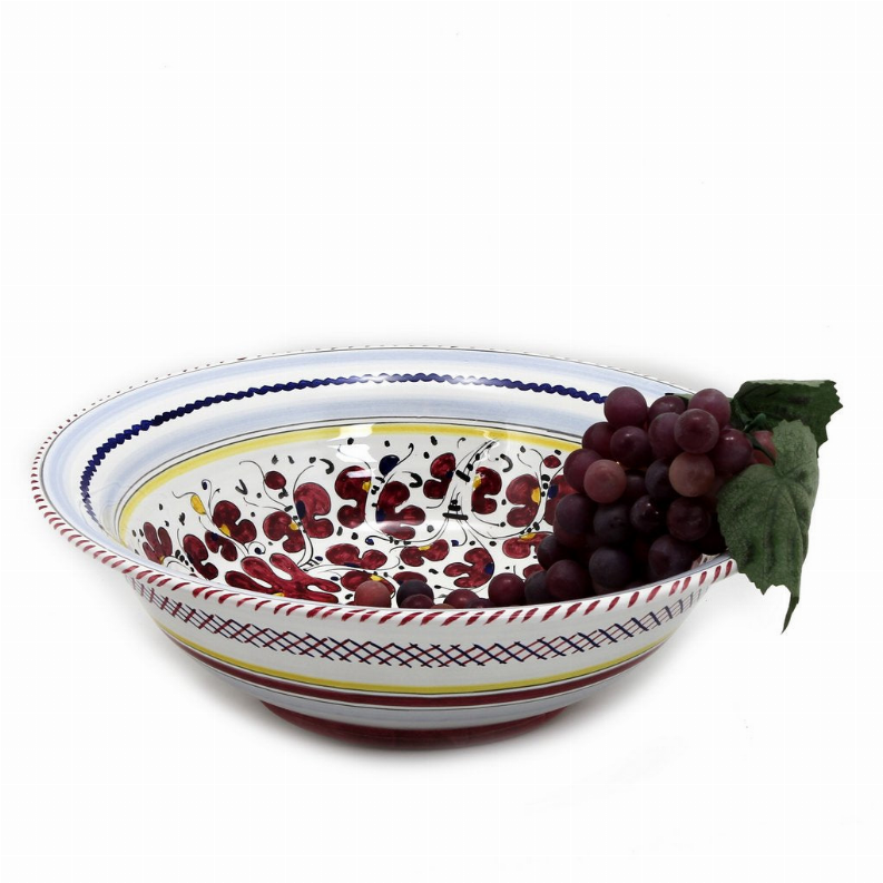 Rooster serving bowl with blue rim and red motif, topped with grapes and green leaves.