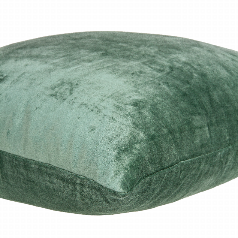 Green solid throw pillow angled close-up showing textured fabric surface