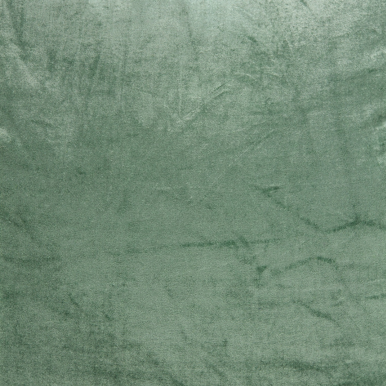 Close-up of green textured throw pillow fabric with mottled pattern