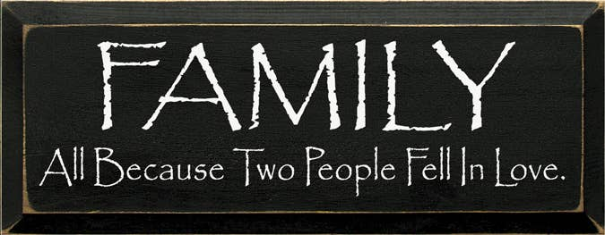 Dark wood wall sign with white text: "FAMILY" and "All Because Two People Fell in Love."