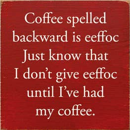 Red wooden quote sign with white text about coffee; square with rounded corners.