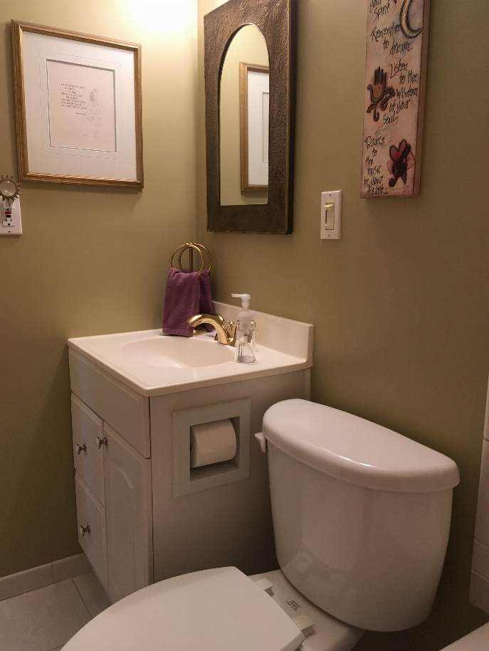 Recessed solid wood toilet paper holder in bathroom wall with toilet paper roll installed