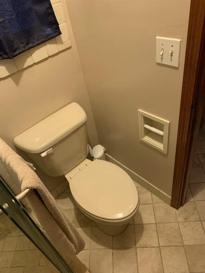 Solid wood recessed toilet paper holder mounted on bathroom wall with white roll