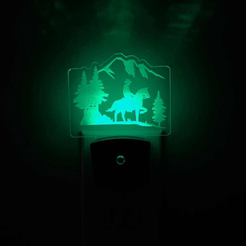 LED nightlight with green cowboy-and-horse mountain scene over black base