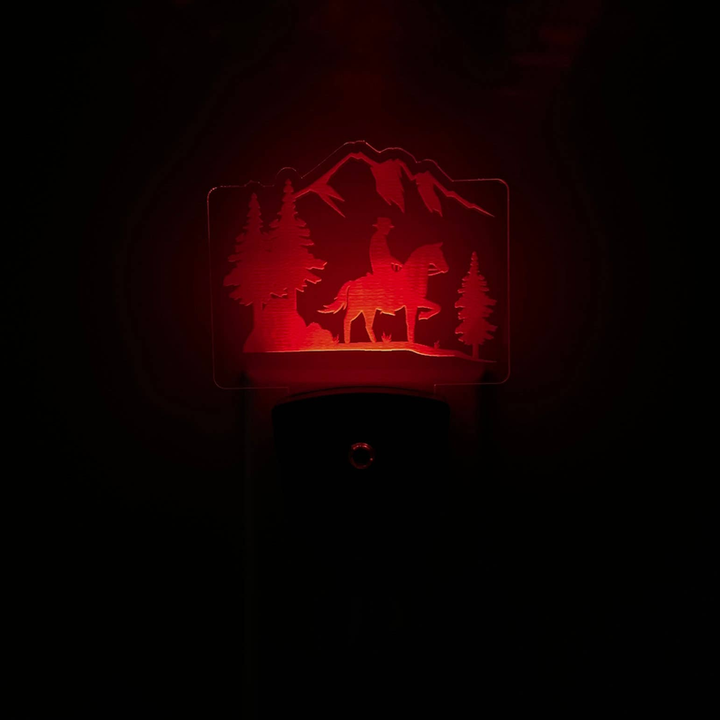 LED nightlight with red cowboy-and-horse mountain scene over black base