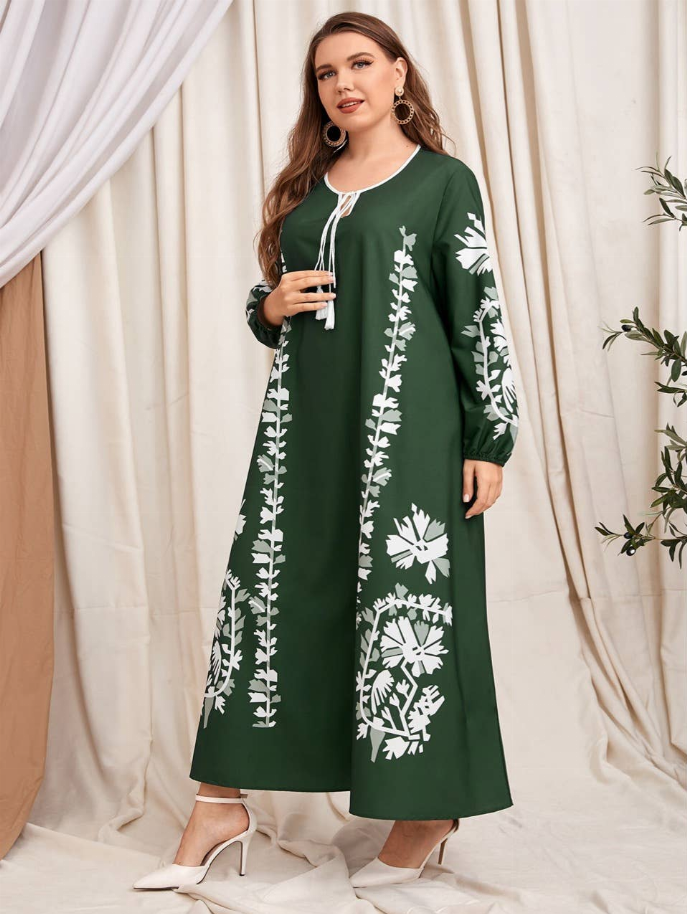 Green long-sleeve midi dress with white floral motifs, round neckline with tassel