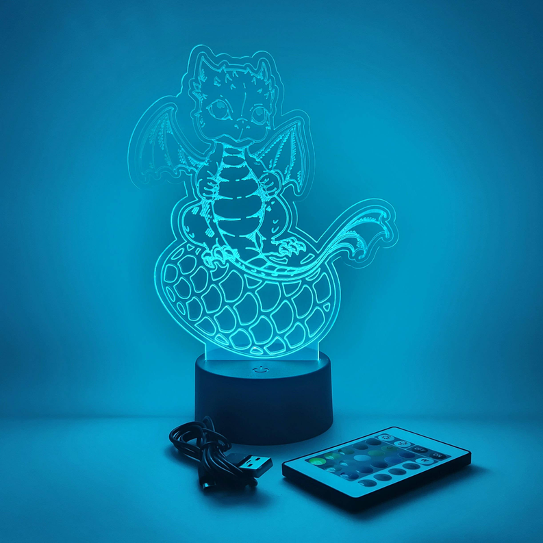 Baby dragon LED lamp with blue glow outline on black base, includes USB cable and remote