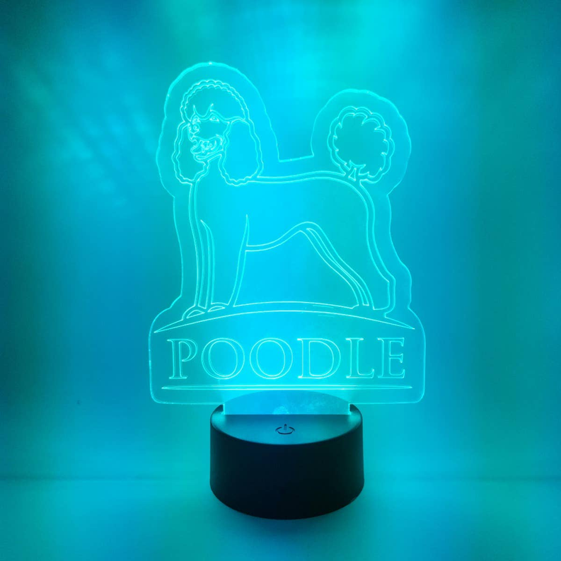 Black cylinder poodle LED lamp casting blue 'POODLE' outline light
