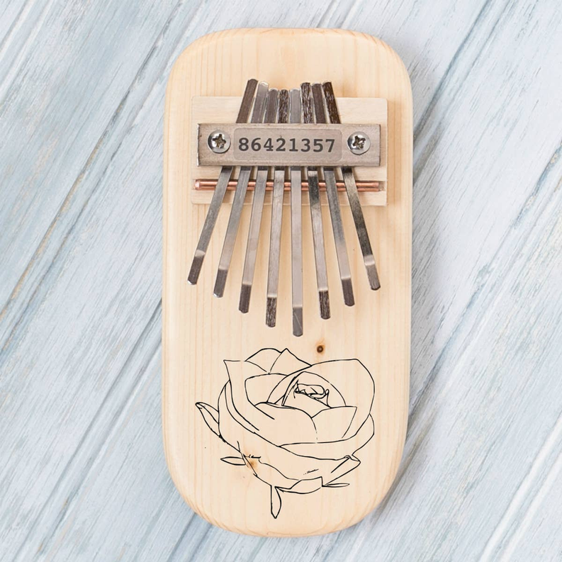 Rose-engraved thumb piano in light pine wood with metal keys