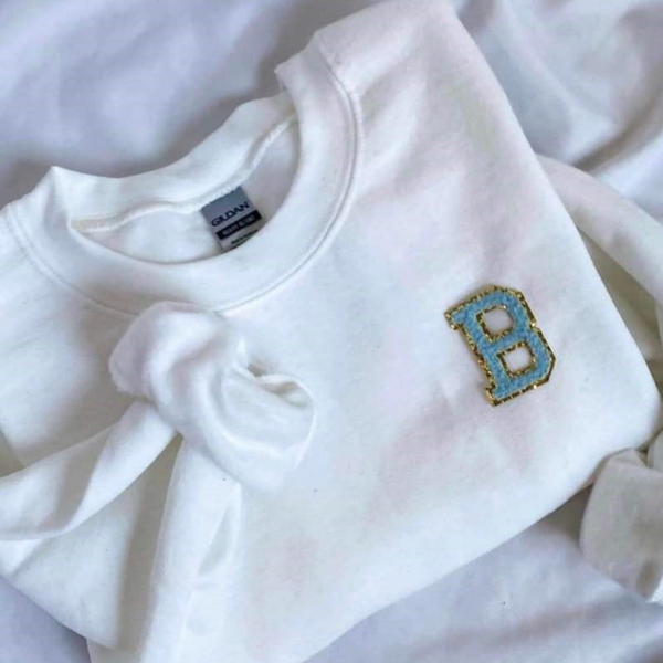 Women's white sweatshirt with light blue and gold “B” applique on the chest