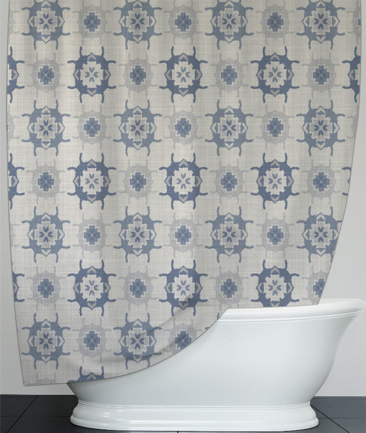 Blue and gray patterned shower curtain drapes over the tub edge with star medallions.