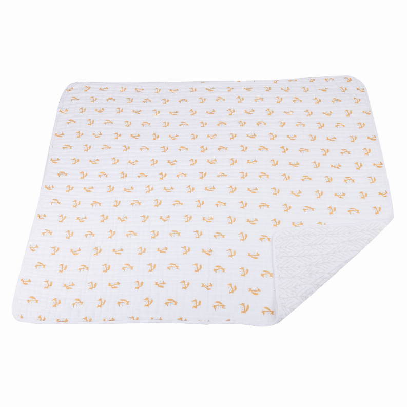 Baby blanket with small orange fox repeat on white, with quilted leaf pattern corner