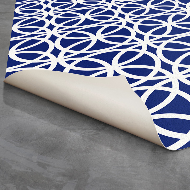 Navy geometric rug with white loop-circle pattern, rolled edge visible