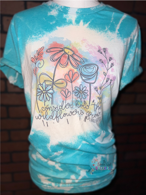 Blue-green bleached graphic tee with floral bird design and script text