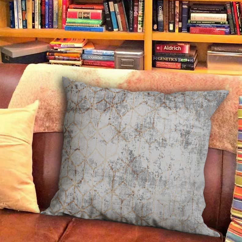Square decorative pillow in distressed gray with gold lattice pattern