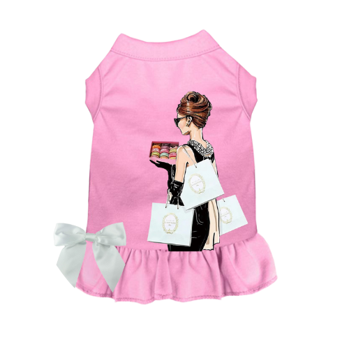 Pink sleeveless dog dress with ruffled hem and illustrated shopper holding bags