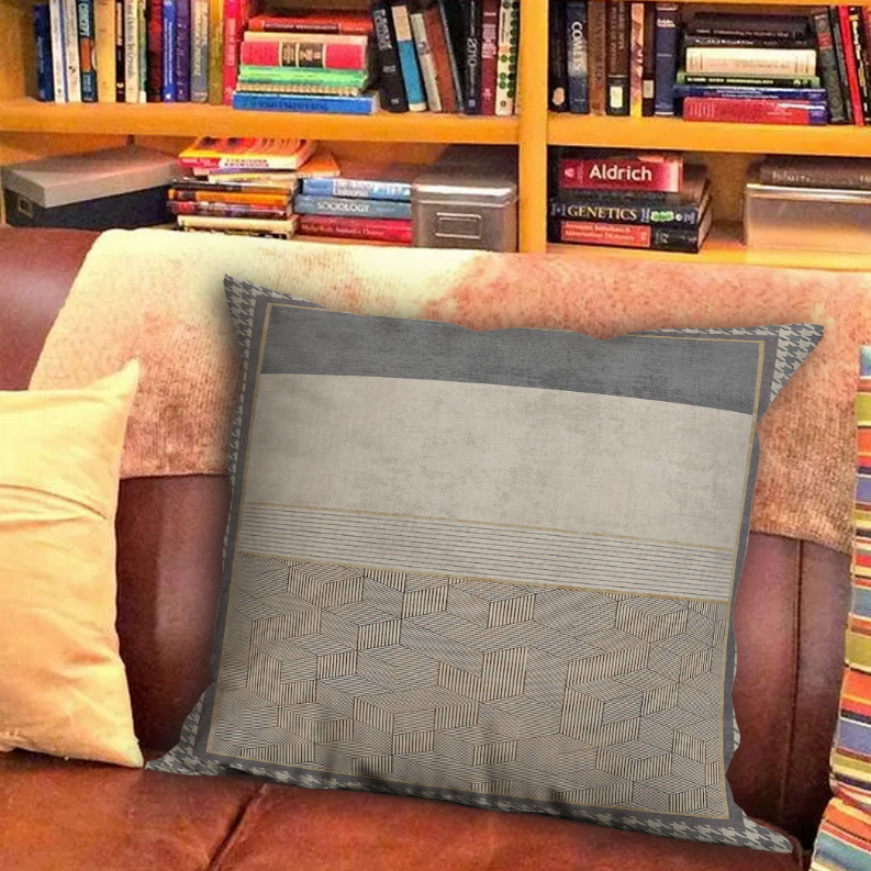 Geometric patterned gray throw pillow with beige center stripe and stitched border trim