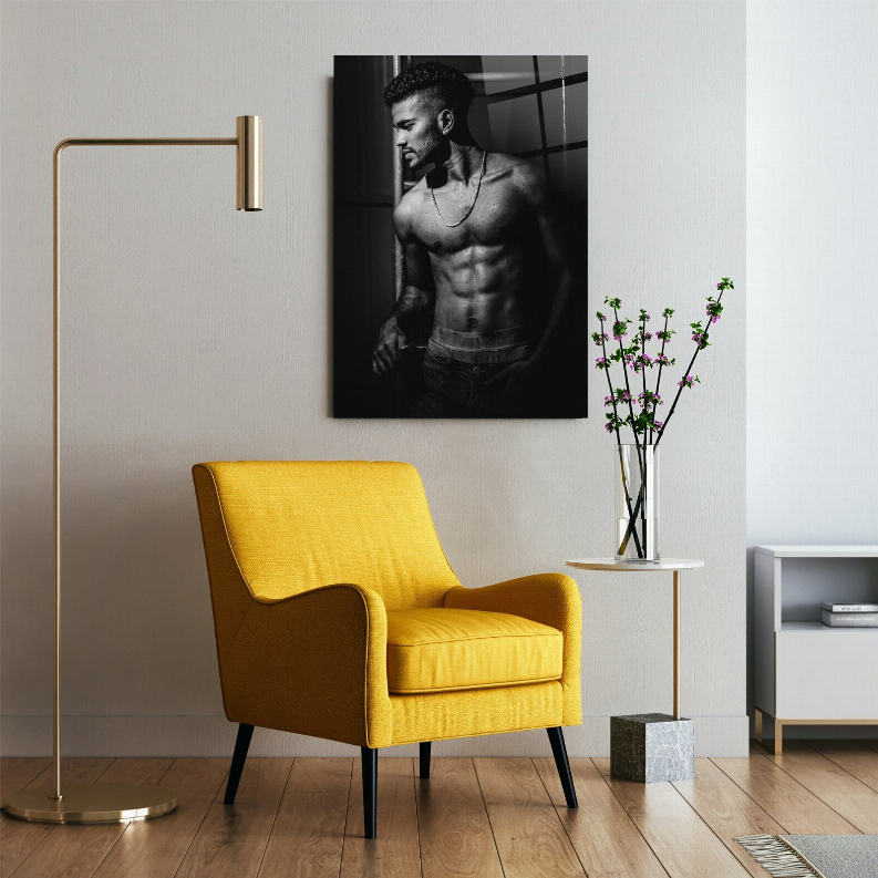 Framed black-and-white wall art print of a muscular man torso, mounted in a room scene