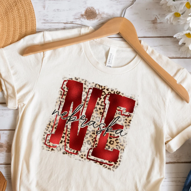 White T-shirt with red Nebraska graphic and leopard-print square patch