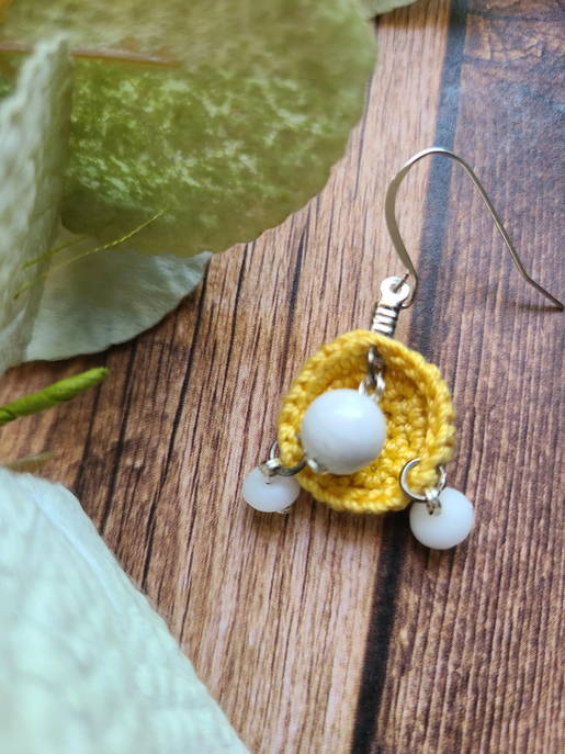 Yellow woven hoop earrings with white round beads and two small white dangles