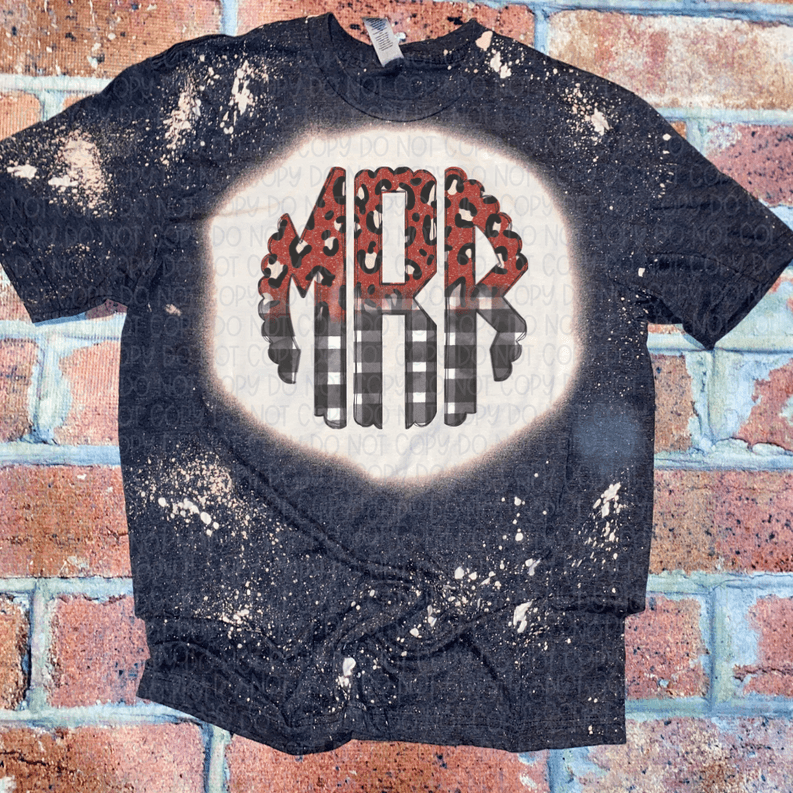 Dark graphic Christmas tee with bleached speckles and red monogram letter in a circle