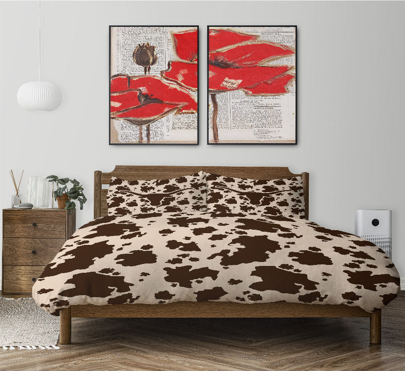 Cow print comforter set with two decorative pillows on a wooden bed frame