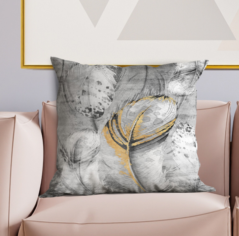 Gray and yellow feather print throw pillow on light sofa, centered