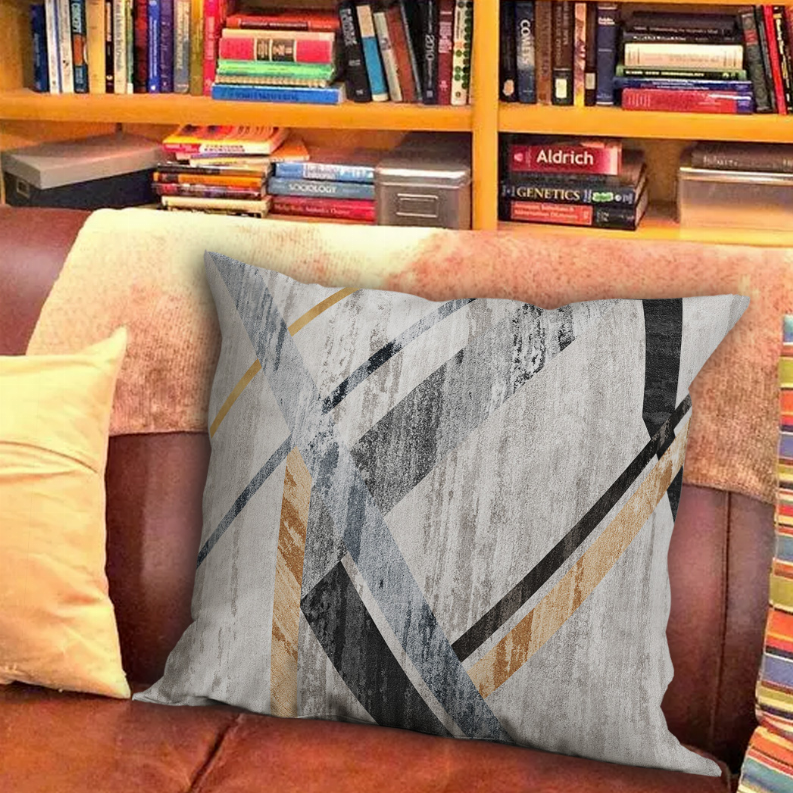 Decorative throw pillow with gray and black geometric stripes on light fabric