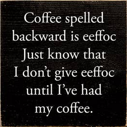 Coffee-themed wooden wall sign with white quote text on dark background