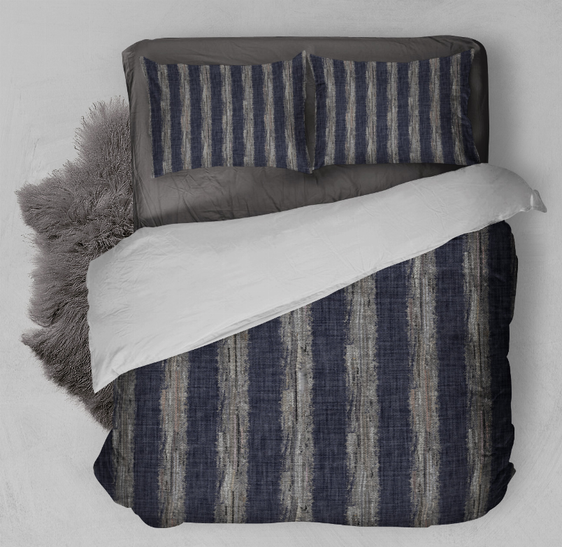 Blue and navy vertical stripe comforter set with pillow shams layered on bed