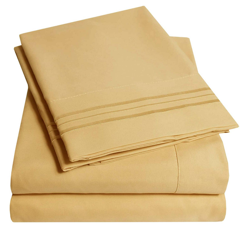 Gold bedding sheet set with stacked flat sheet and fitted sheet
