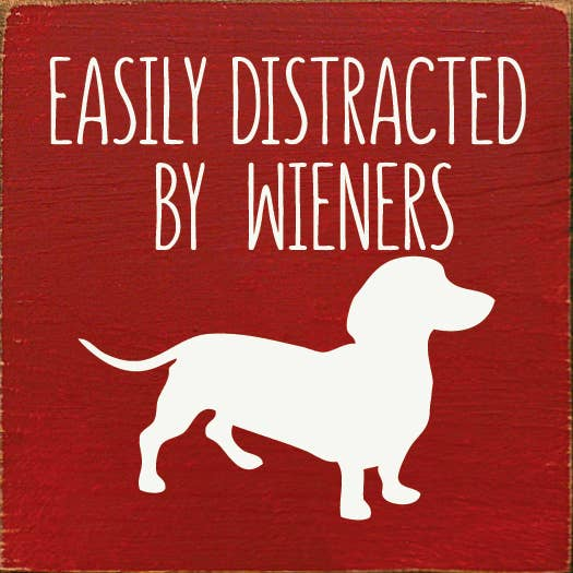 Red decorative wood sign with white text 'Easily Distracted' and dachshund silhouette
