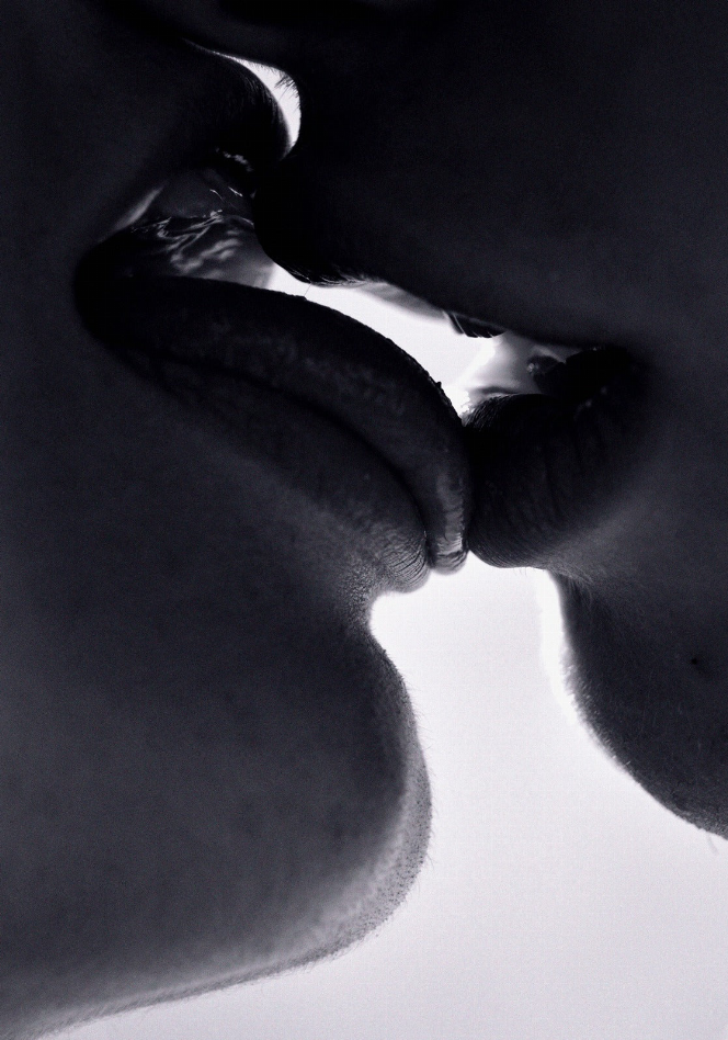 Square black glass wall art with black-and-white kissing faces silhouette