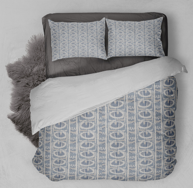 Blue geometric duvet cover set with two matching pillow shams, laid on bed
