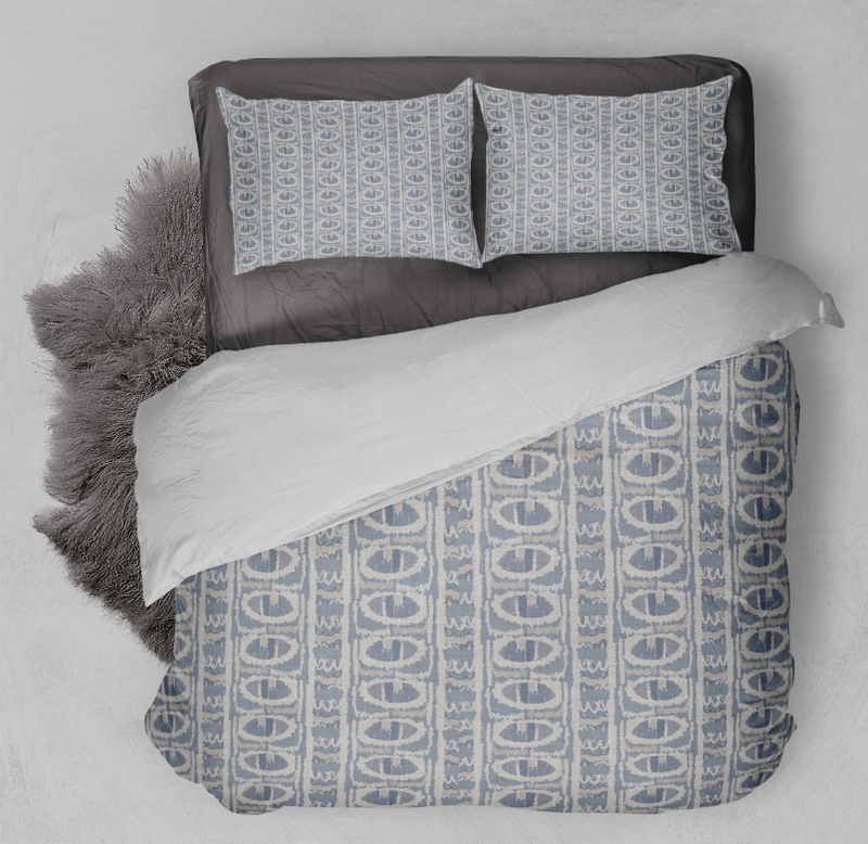 Blue geometric duvet cover set with two matching pillow shams, laid on bed