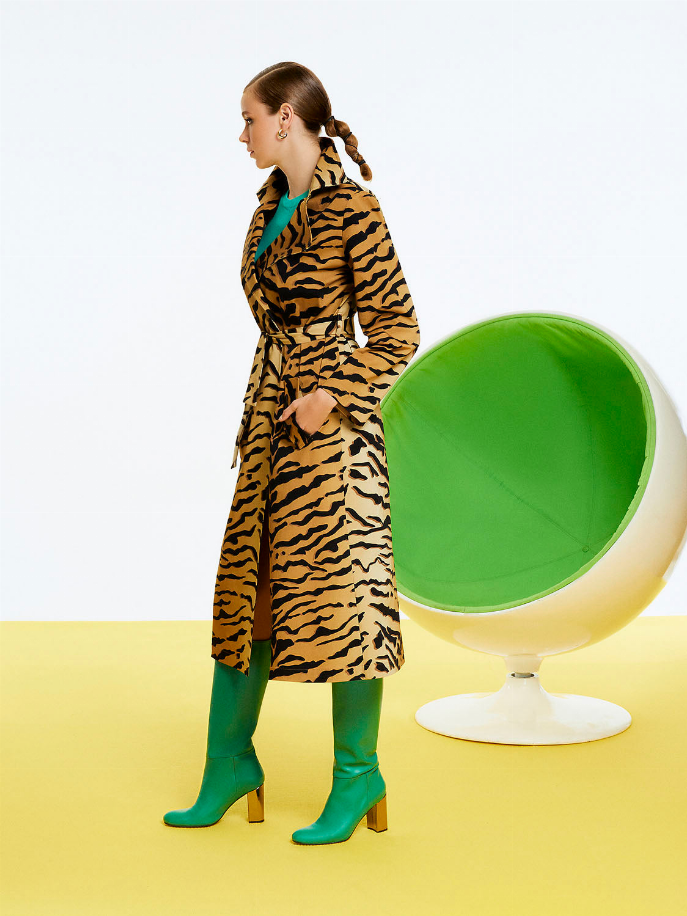 Side view of belted tiger-print trench coat with long sleeves and notched collar