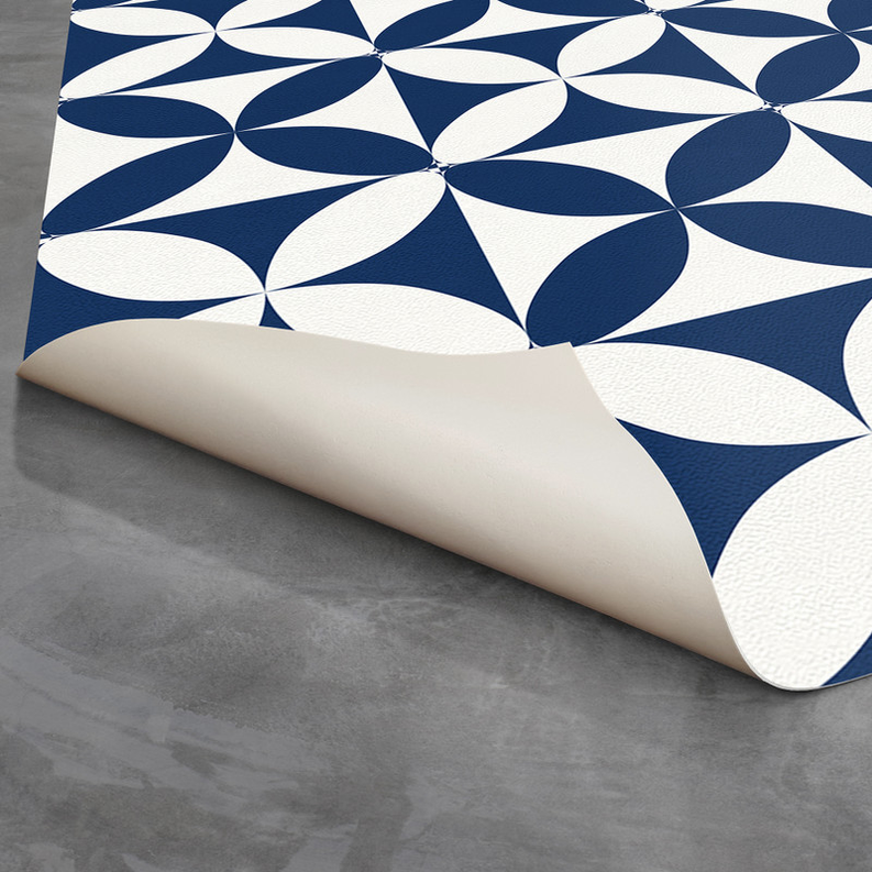Geometric rug with navy and white flower pattern, rolled edge view