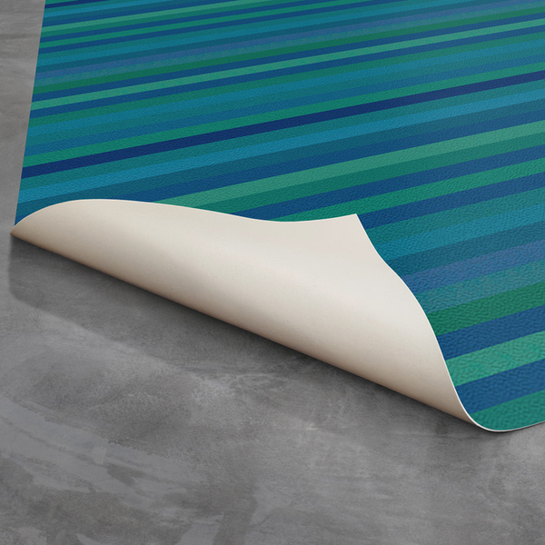 Teal striped indoor/outdoor rug with non-slip backing, shown rolled at the corner