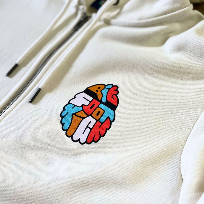 Cream zip-up hoodie with colorful Bigfoot patch logo and front zipper