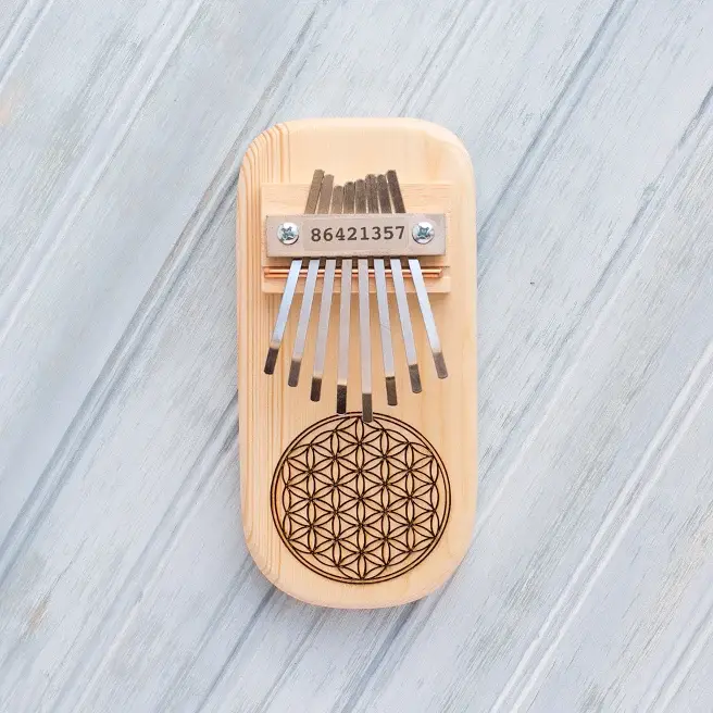 Light wood kalimba thumb piano with flower of life engraving and metal tines