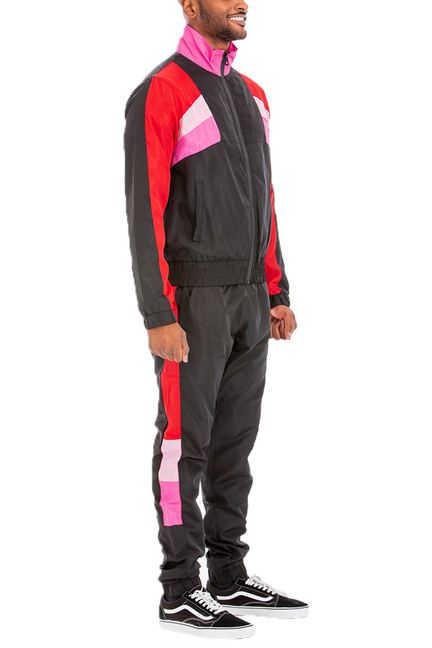 Winslow windbreaker track set, side view: zipped jacket and black joggers with pink/red panels
